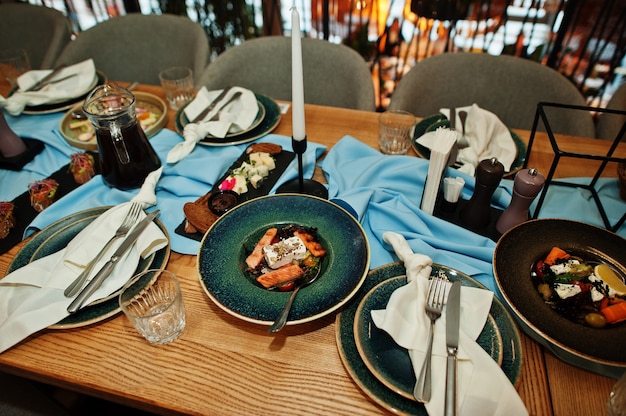 Tavoli splendidamente apparecchiati con cibo, bicchieri ed elettrodomestici nel ristorante.