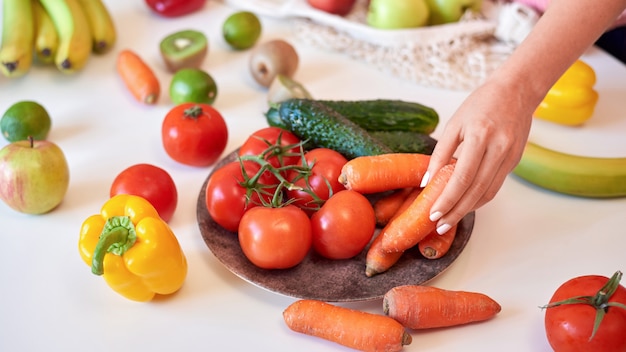 Tavolo bianco con donna raccolta carota