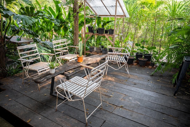 Tavolo bianco e sedie sulla terrazza in giardino al giorno d'estate.