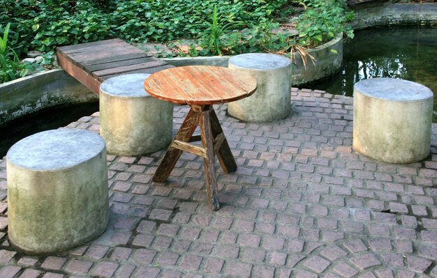 tavolo circolare in legno e sedie in cemento in un parco