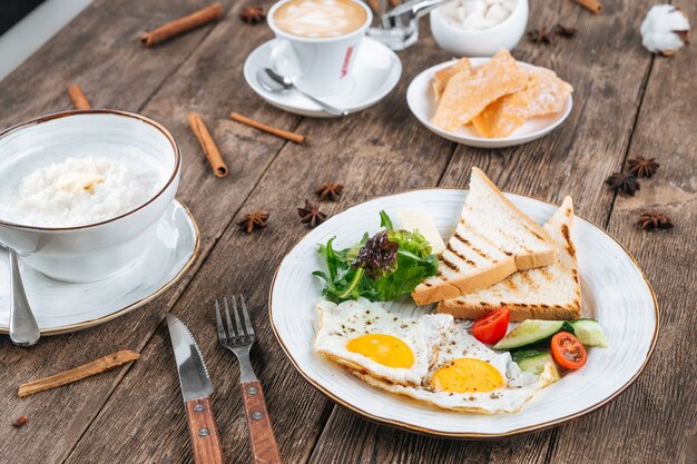 Tavolo con colazione a base di uova fritte e porridge