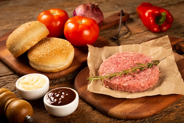 Tavolo con ingredienti per hamburger Hamburger crudo