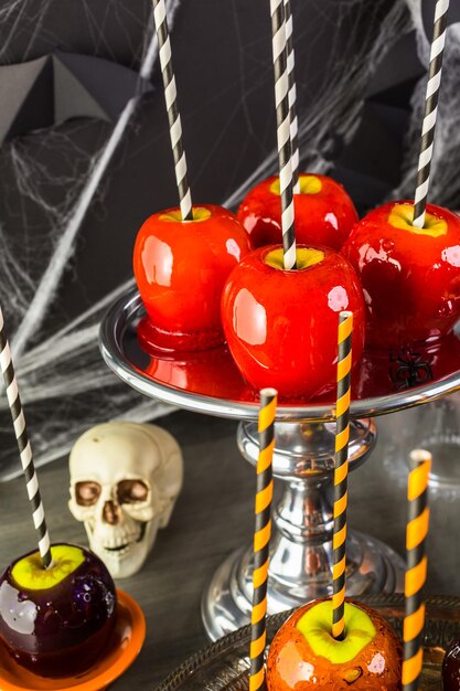 Tavolo con mele caramellate colorate e torta per la festa di Halloween.