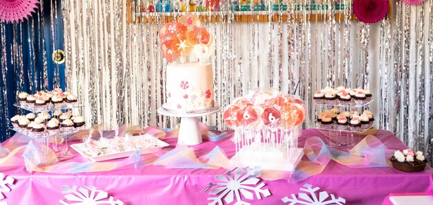 Tavolo con torta e dolci alla festa di compleanno della bambina.