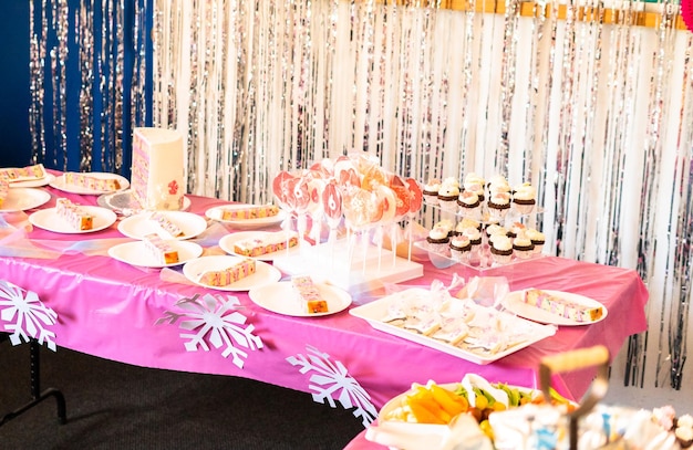 Tavolo con torta e dolci alla festa di compleanno della bambina.