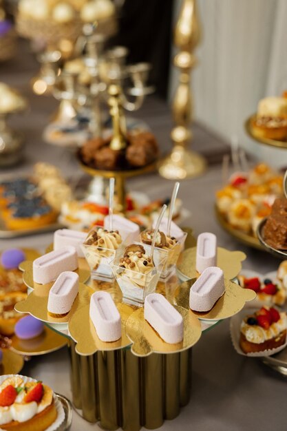 Tavolo con torte dolci buffet di caramelle Tavolo da dessert per una festa golosità per l'area del banchetto di nozze