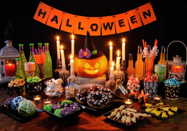 Tavolo da buffet con dolci e bevande, cucinati e decorati in onore di Halloween