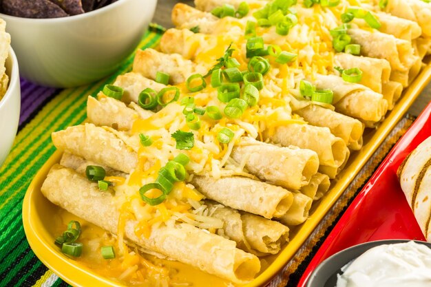 Tavolo da buffet per feste Fiesta con taquitos di pollo e altri piatti tradizionali messicani.