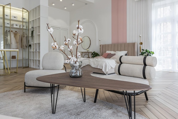 Tavolo da caffè creativo e mobili imbottiti alla moda nel soggiorno in uno spazioso appartamento a pianta aperta con un elegante design moderno e luminoso in una giornata di sole