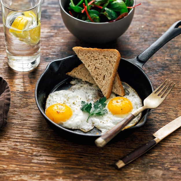 Tavolo da colazione Uova di pollo fritto insalata di pane acqua di limone