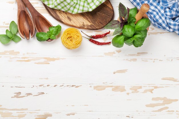 Tavolo da cucina con utensili e ingredienti su legno bianco Vista dall'alto con spazio per la tua ricetta