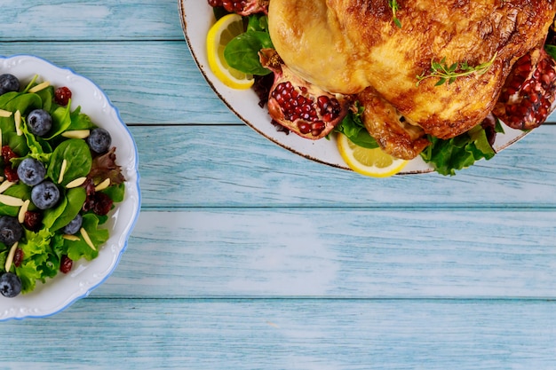 Tavolo da festa con insalata e pollo intero per le vacanze