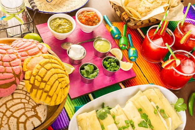 Tavolo da festa con tamales, margarita alla fragola e pan dulche.