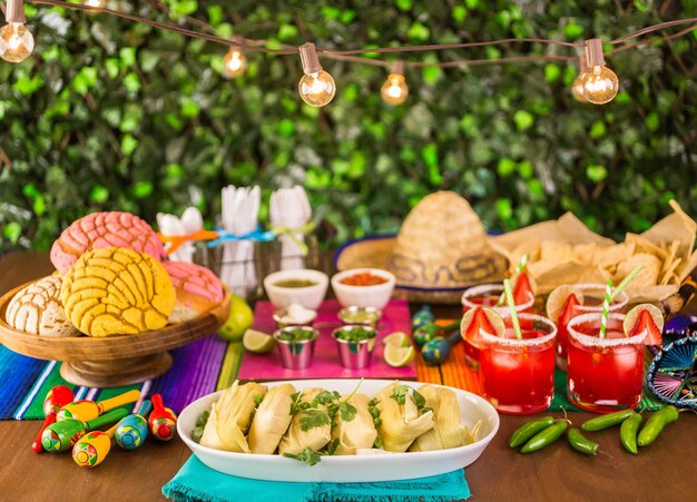 Tavolo da festa con tamales, margarita alla fragola e pan dulche.