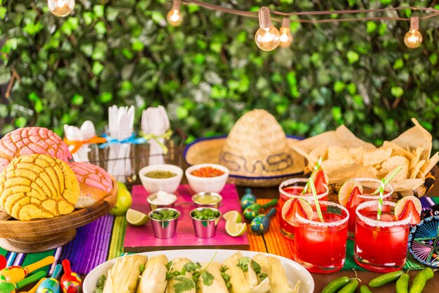 Tavolo da festa con tamales, margarita alla fragola e pan dulche.