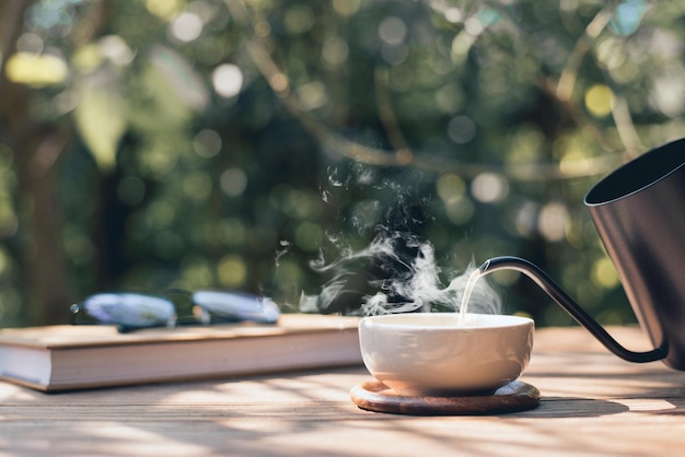 Tavolo da lettura da giardino Versare il tè nella tazza da tè Primo piano