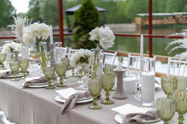 Tavolo da matrimonio decorato con peonie bianche e piume Sedie Chiavari giorno d'estate Vista diagonale