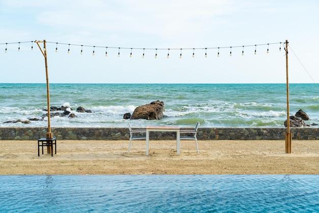 Tavolo da pranzo e sedia sulla spiaggia con sfondo mare