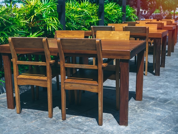 Tavolo da pranzo in legno allestito vicino al verde giardino