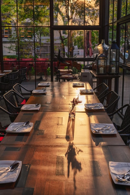 Tavolo da pranzo in legno e sedie in un edificio industriale moderno al tramonto