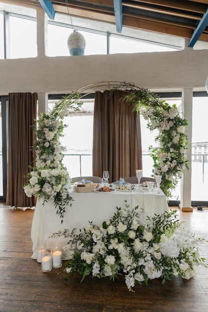 Tavolo da sposa romantico con eleganza di arco floreale