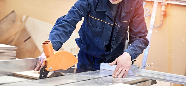 Tavolo da taglio per legno con sega circolare elettrica Ebanista esperto che utilizza la sega circolare presso officina di lavorazione del legno Falegname professionista taglio tavola di legno presso segheria Segatrice