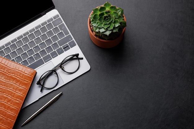 Tavolo da ufficio con tazza di caffè e rifornimenti per laptop