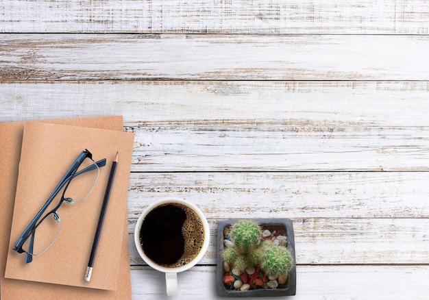 Tavolo da ufficio in legno con tazza di caffè per notebook e bicchieri piatti Vista dall'alto con spazio per la copia