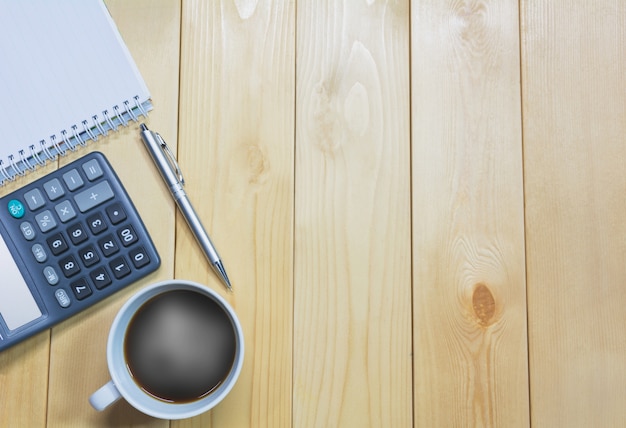 Tavolo da ufficio vista dall&#39;alto con carta e caffè e calcolatrice e penna per il business