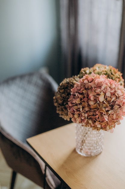 Tavolo da vaso in vetro con fiori decorativi all'interno di una casa