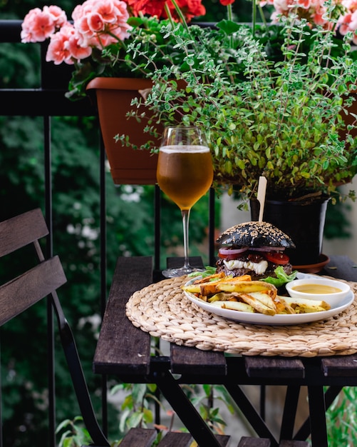 Tavolo del ristorante sulla terrazza con hamburger dal panino nero