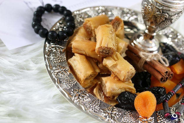 Tavolo di dolci orientali su un piatto d'argento baklava e snack al tamarindo sul posto di lavoro