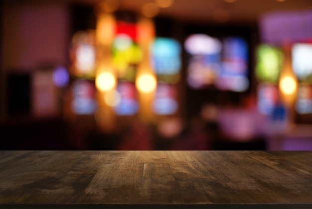 Tavolo di legno scuro vuoto davanti astratto sfocato sfondo bokeh del ristorante. può essere utilizzato per visualizzare o montare i tuoi prodotti. Abbassare lo spazio.
