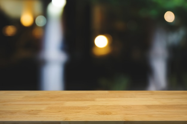 tavolo di legno vuoto con caffè sfocato, sfondo di visualizzazione del montaggio del prodotto.