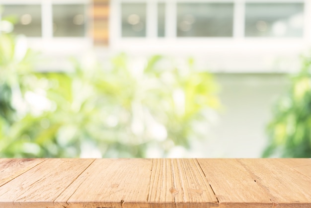 Tavolo di legno vuoto davanti astratto sfondo offuscata di caffè. può essere utilizzato per la visualizzazione o il montaggio dei prodotti