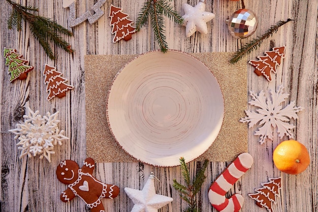 Tavolo di Natale servito Piatto vintage beige mock up mandarini biscotti di pan di zenzero fatti a mano Decorazioni natalizie sul tavolo Giocattoli alla moda per l'albero di Natale Mockup estetico Vista dall'alto