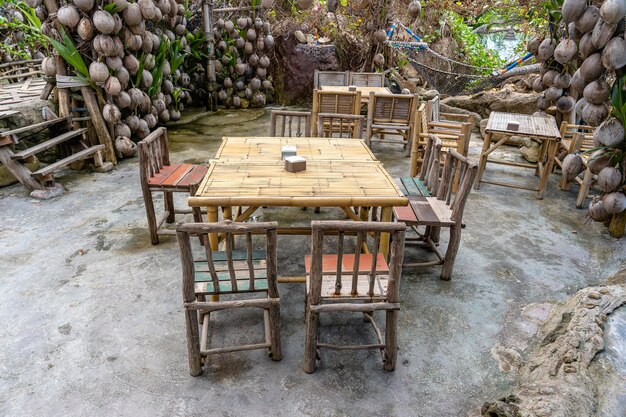 Tavolo e sedie in legno nel bar sulla spiaggia vuota vicino all'isola del mare Koh Phangan Thailandia