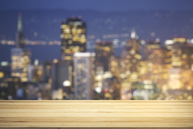 Tavolo in legno bianco con bellissimo skyline sfocato di notte su sfondo mockup