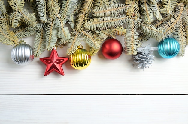 tavolo in legno bianco con rami di albero di Natale e giocattoli