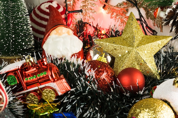 Tavolo in legno con decorazioni natalizie. Palline rosse, argento e oro, scatole regalo, luci, Babbo Natale, Panettone, albero di Natale e altro. Messa a fuoco selettiva.