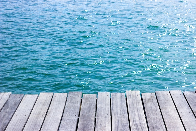 Tavolo in legno con sfondo blu del mare.