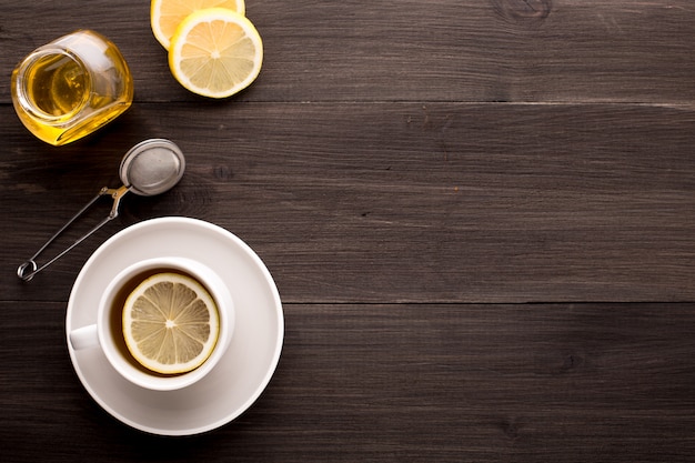 Tavolo in legno con tè nero, limone e miele