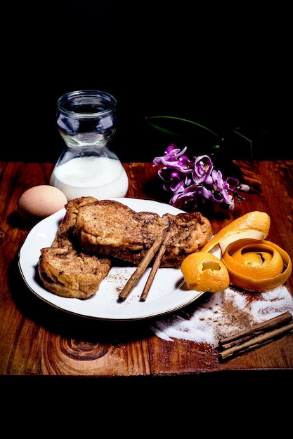 Tavolo in legno con toast francese tipico dolce spagnolo a Pasqua con zucchero e cannella latte