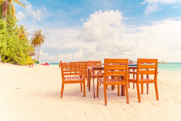 tavolo in legno e sedia sulla spiaggia con vista mare alle Maldive