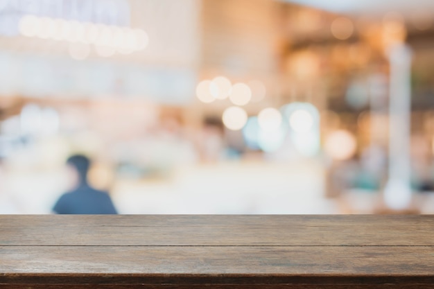 Tavolo in legno e sfondo interno ristorante sfocato - può essere utilizzato per la visualizzazione o il montaggio dei vostri prodotti.