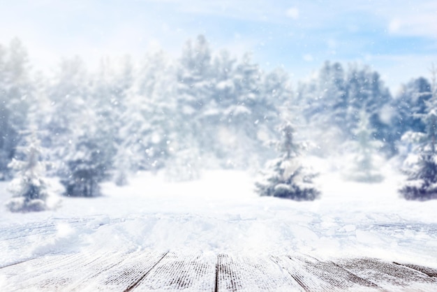 Tavolo in legno innevato sullo sfondo di una foresta invernale