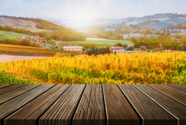 Tavolo in legno marrone nel paesaggio autunnale del vigneto con spazio vuoto per l'esposizione del prodotto