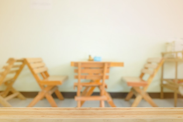 Tavolo in legno su sfocato sala da pranzo con illuminazione calda.