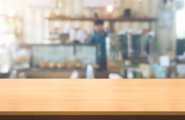 Tavolo in legno sullo sfondo sfocato della moderna sala ristorante o caffetteria per il mockup di visualizzazione del prodotto