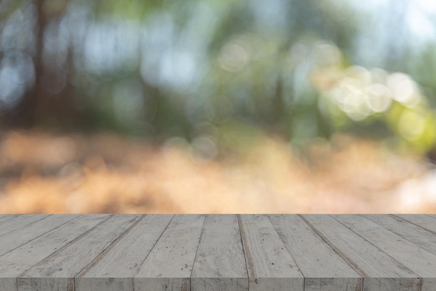 Tavolo in legno vuoto con bokeh su sfondo natura sfocato